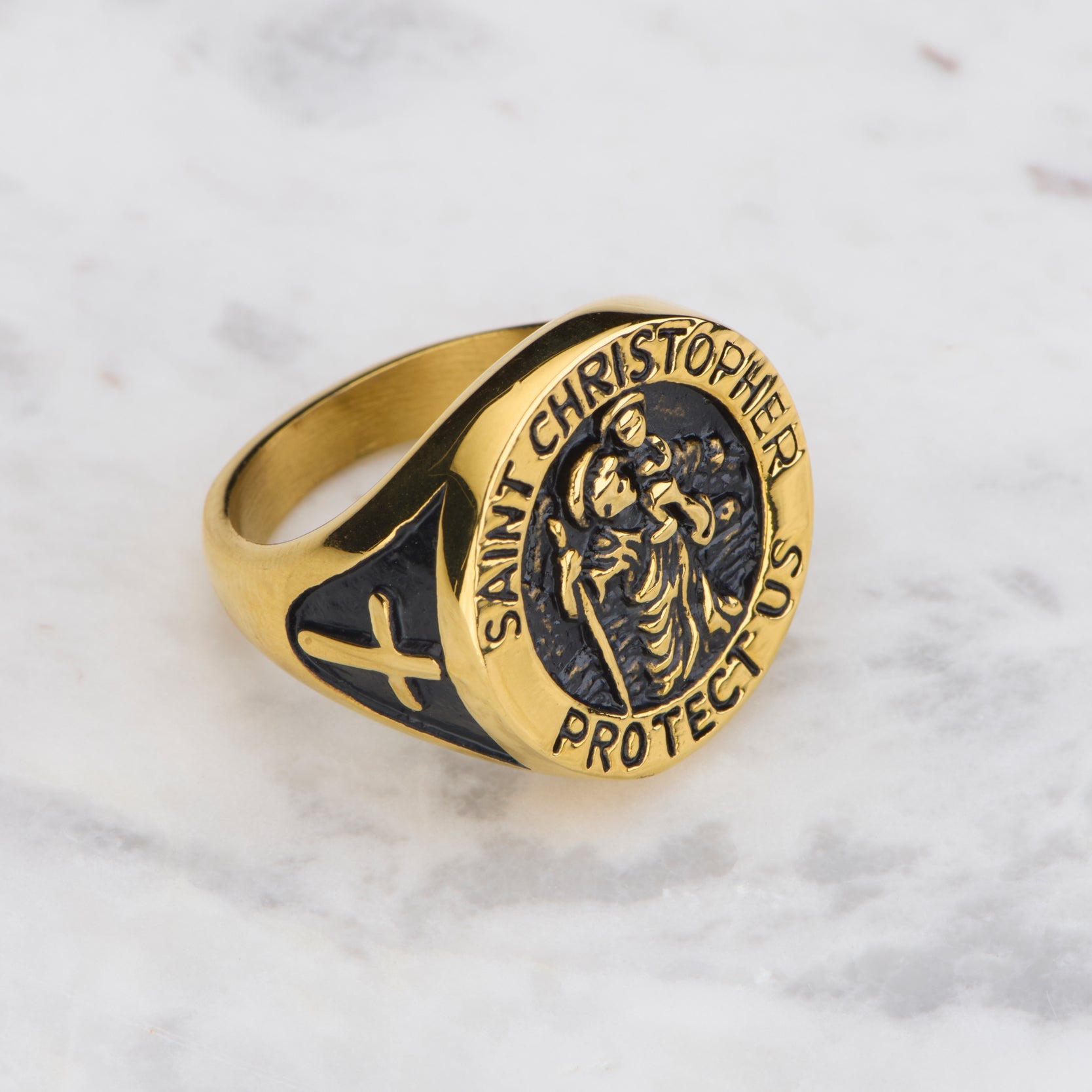 Gold and black Saint Christopher ring on a light gray background