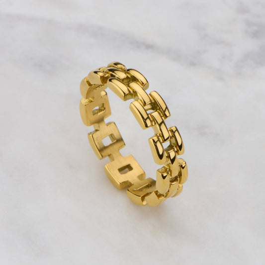 Gold chain-style ring on a light gray background