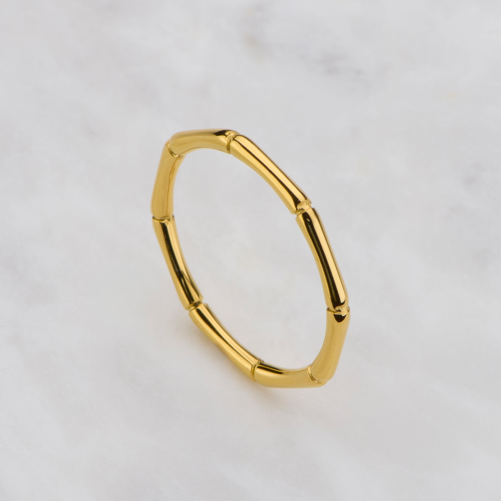 Gold hoop earring on a light gray background