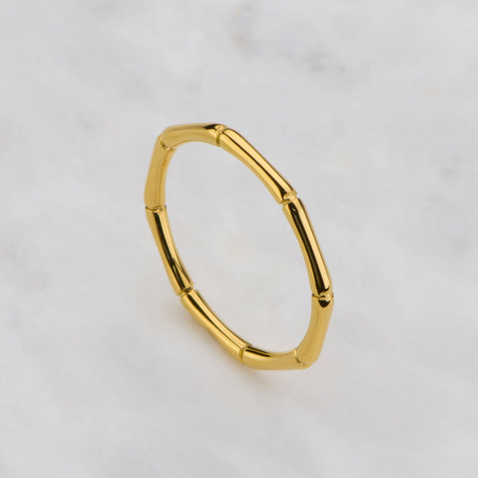 Gold hoop earring on a light gray background