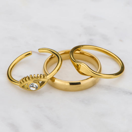 Three gold rings on a marble surface