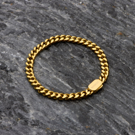 Gold chain ring on a dark stone surface