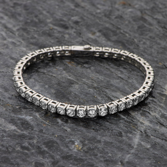 Silver bracelet with clear stones on a dark stone surface