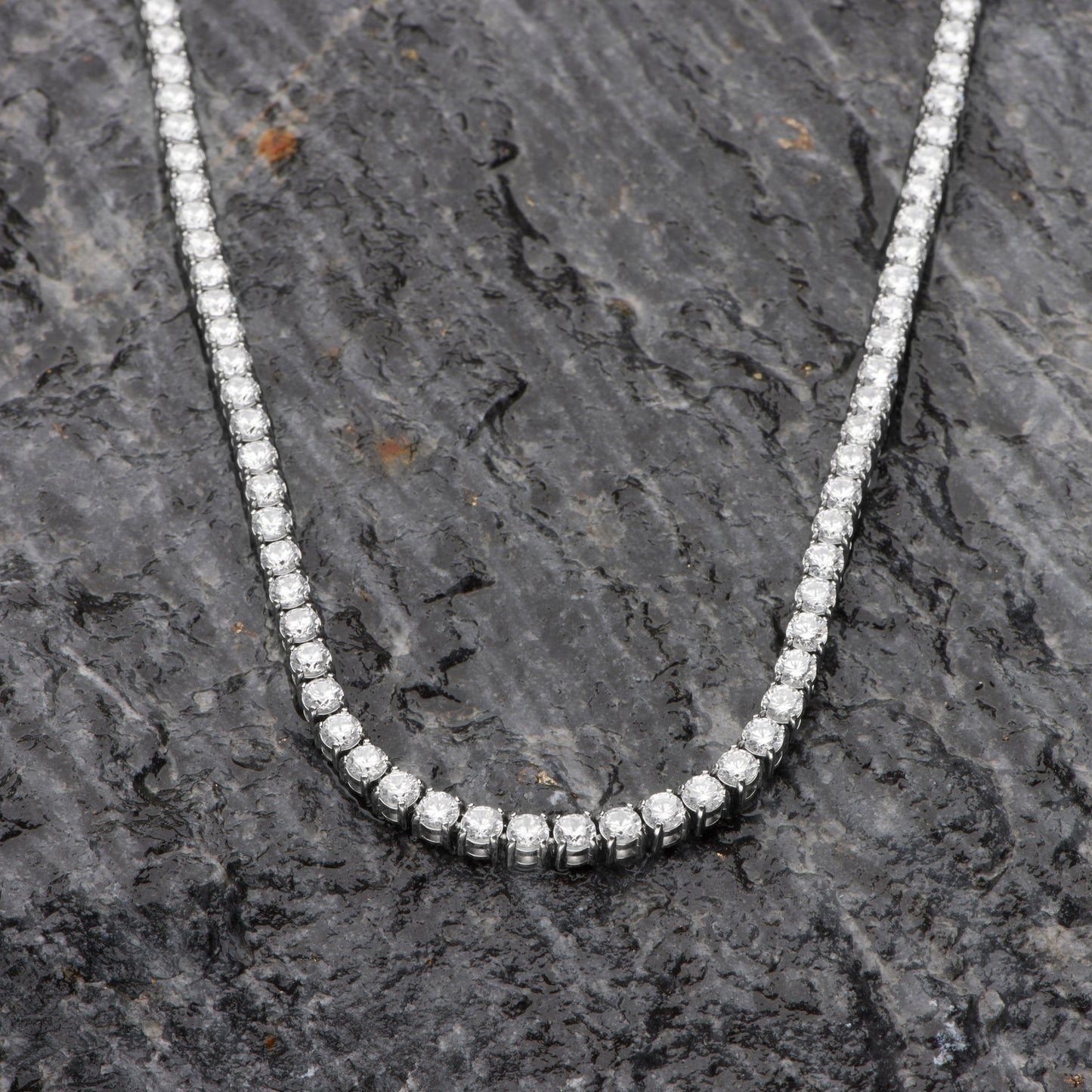 Diamond necklace on a dark stone surface