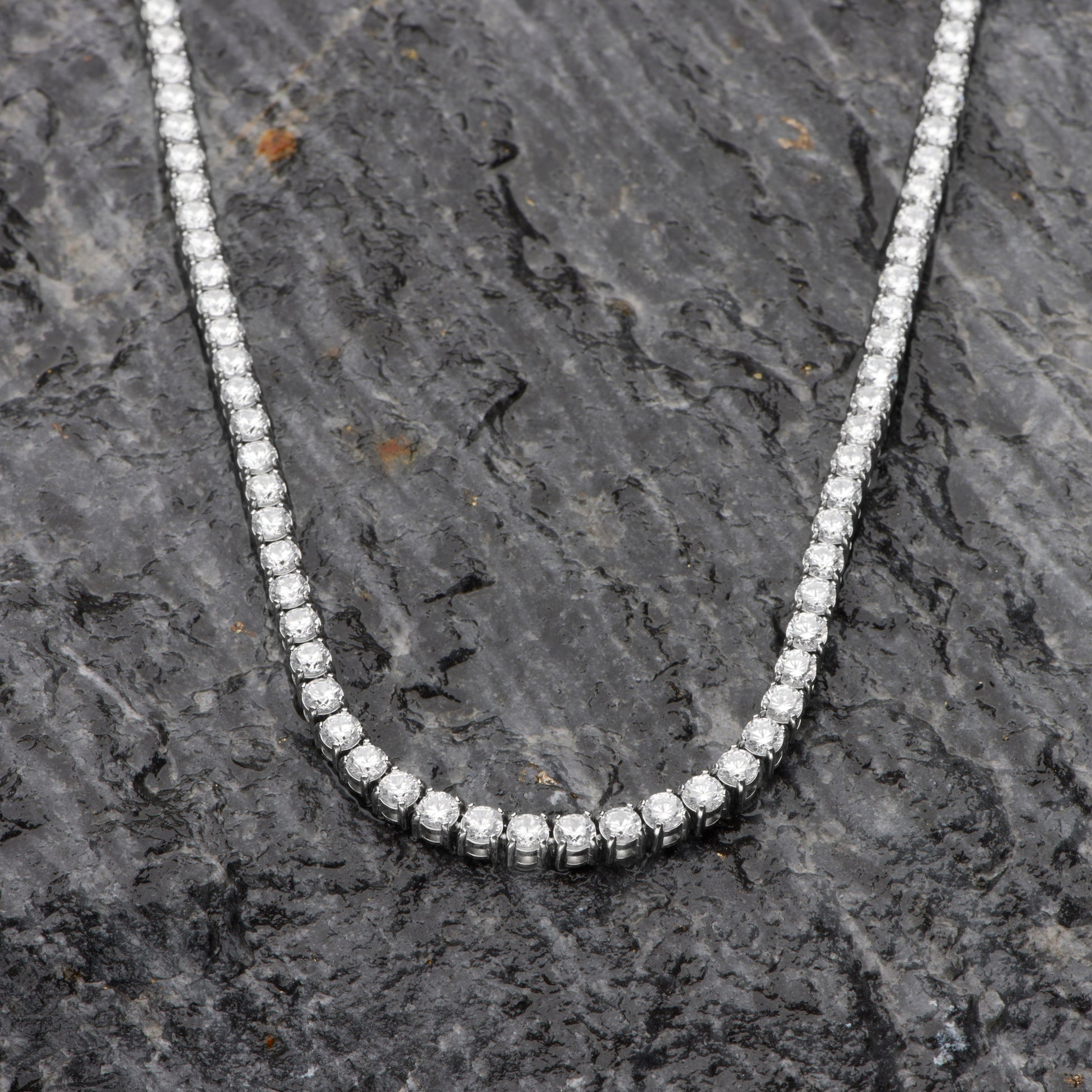 Diamond necklace on a dark stone surface