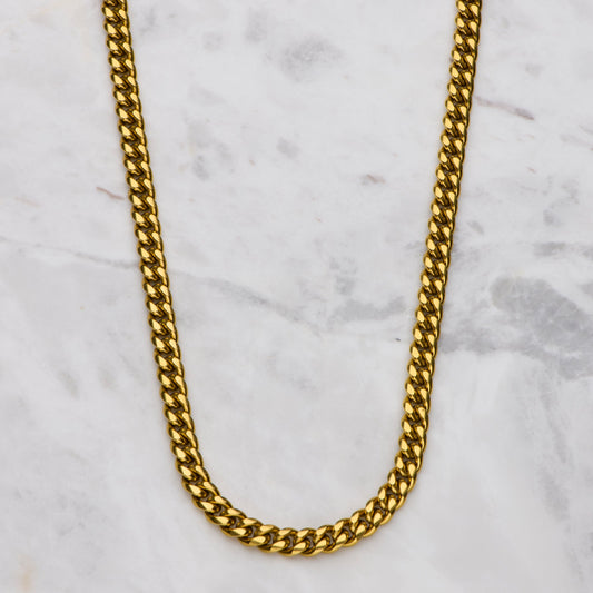 Gold chain necklace on a marble surface