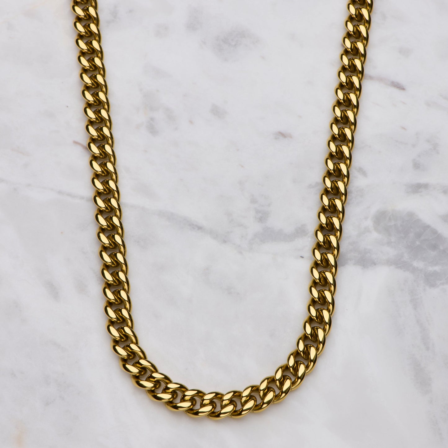 Gold chain necklace on a marble surface