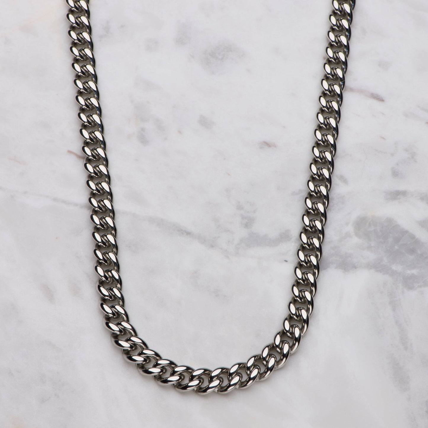Silver chain necklace on a marble surface