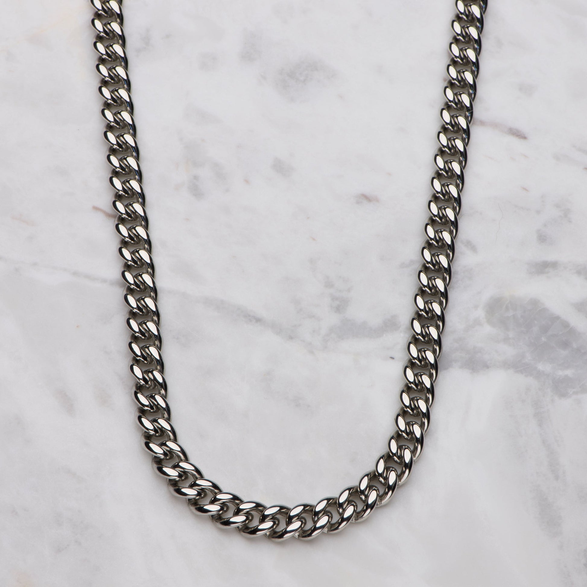 Silver chain necklace on a marble surface
