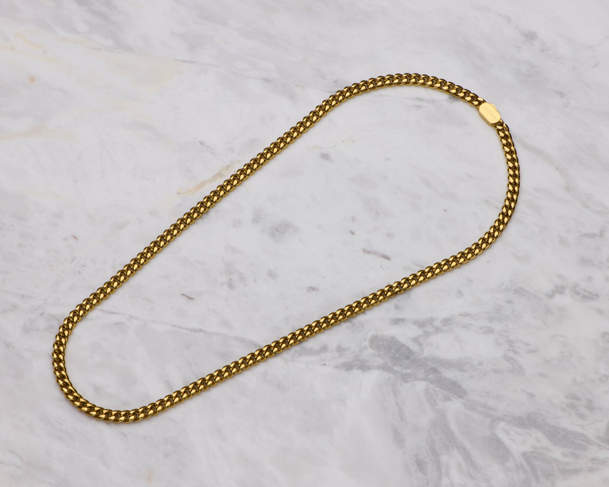 Gold chain necklace on a marble surface