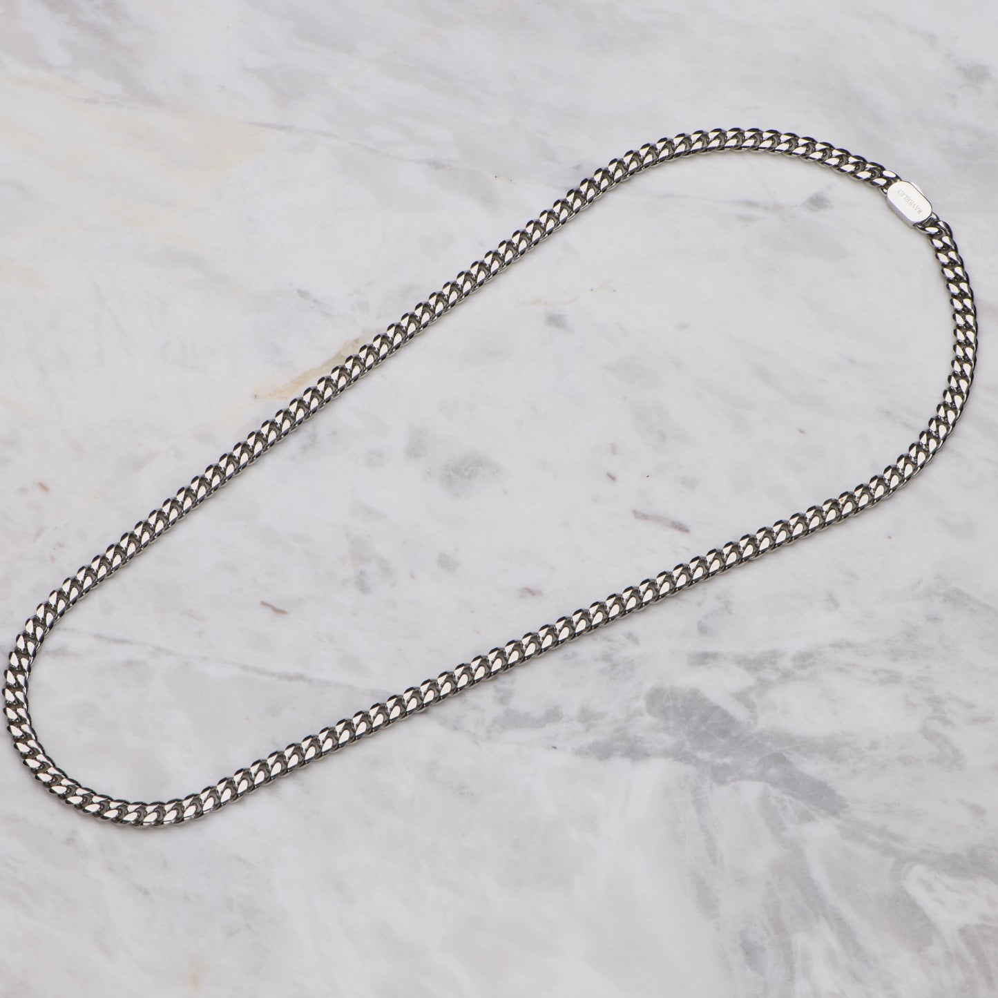 Silver chain necklace on a marble surface