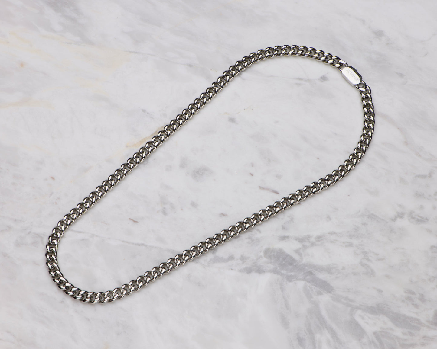 Silver chain necklace on a marble surface