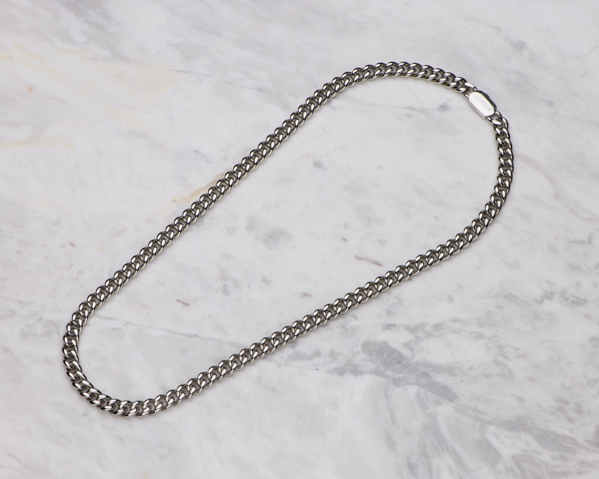 Silver chain necklace on a marble surface
