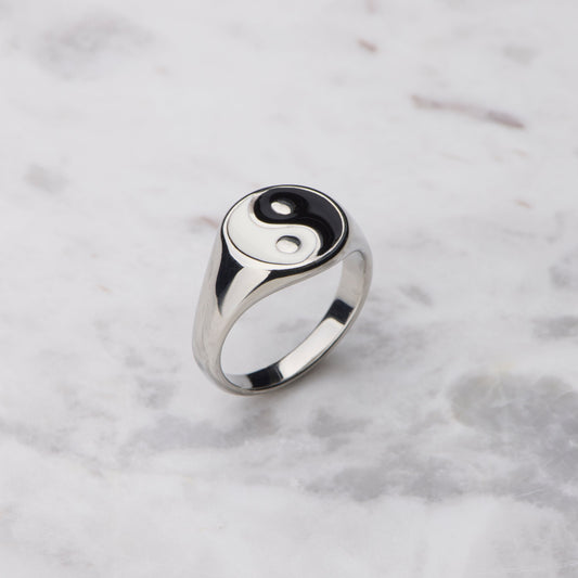 Silver ring with a yin yang symbol on a marble background
