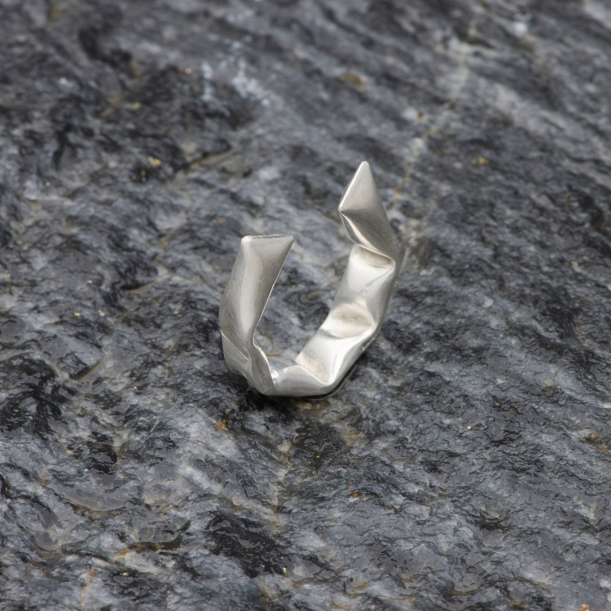 Silver ring on a textured gray stone surface