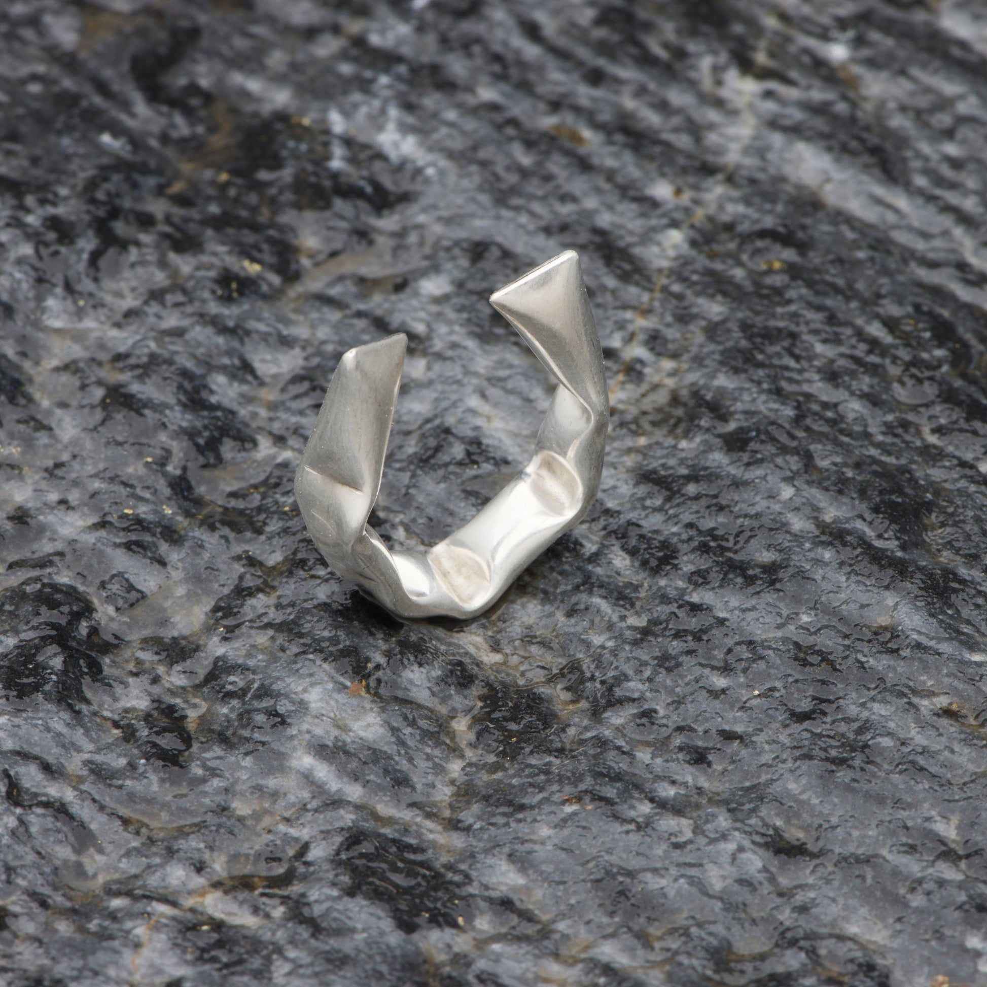 Silver ring on a textured gray stone surface