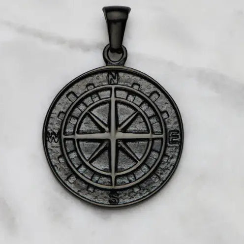 Black metal pendant with star design on a white marble background