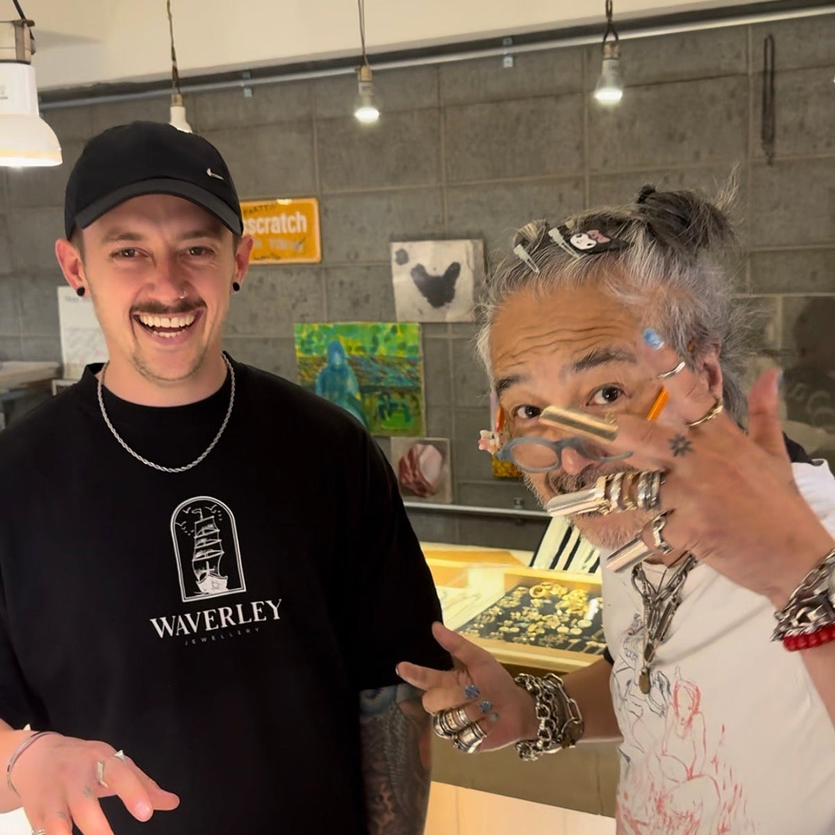 Two people standing in a kitchen, one wearing a black 'Waverley' shirt.