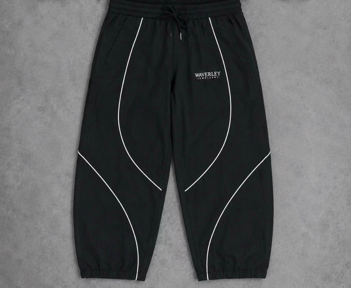 Black pants with white piping on a grey background